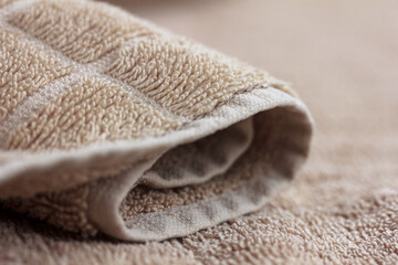 Fototapeta na wymiar Beige, brown towel macro, soft bath blurred background, fabric material, copy space