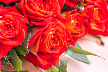 Bouquet of bright red roses close-up. Roses sprinkled with sequins shine in the sun