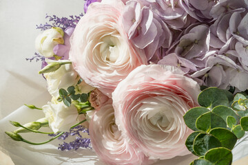 Festive bouquet of white-pink roses and other flowers close-up on a white background