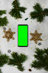 green screen technology cell phone on christmas decoration table top view flat lay, mock up for...