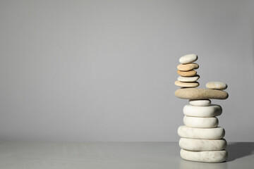 Fototapeta na wymiar Stack of stones on grey background, space for text. Harmony and balance concept