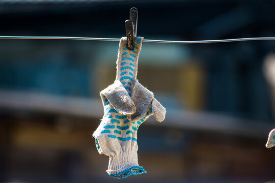 Work gloves to dry on a clothesline, reminiscent of an indecent gesture with a middle finger fuck you