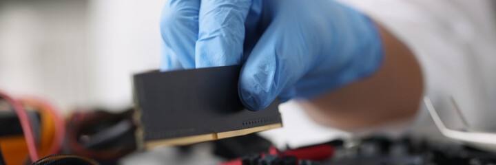 Gloved technician diagnoses broken computer equipment closeup