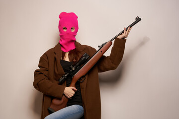 Fototapeta na wymiar woman in pink mask with a gun in hand Lifestyle beige background