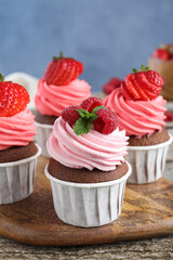 Sweet cupcakes with fresh berries on wooden table, closeup