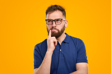 Funny thoughtful man in glasses in studio