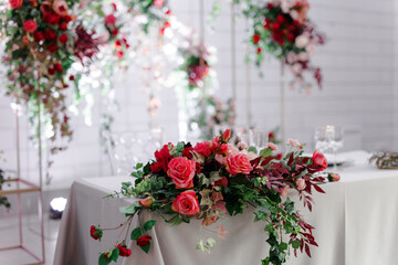 Canned round tables in the white hall. Wedding decorations made of flowers on the tables. the concept of the holiday.