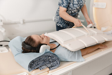 Doctor or nurse and patient with tomography CT or MRI Scan in hospital. Interior of radiography...