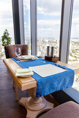 Table for two in skyscraper restaurant overlooking the city. Interior of cozy luxury restaurant with original design