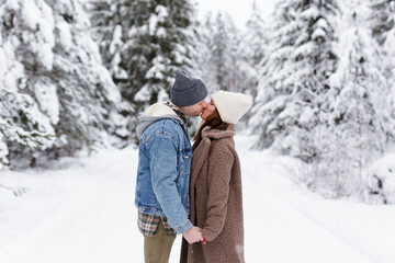 Fototapeta na wymiar beautiful couple in love kissing in winter forest.