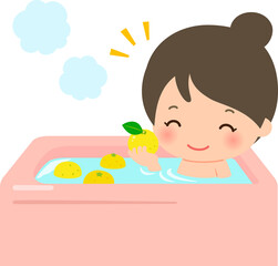 バスタブに柚子を入れ入浴する女性、柚子風呂