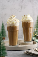  two tall glasses with cold coffee drink - iced cappuccino with whipped cream, christmas decoration...