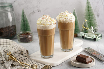 Two tall glasses with cold coffee drink frappe - iced cappuccino with whipped cream on a marble...