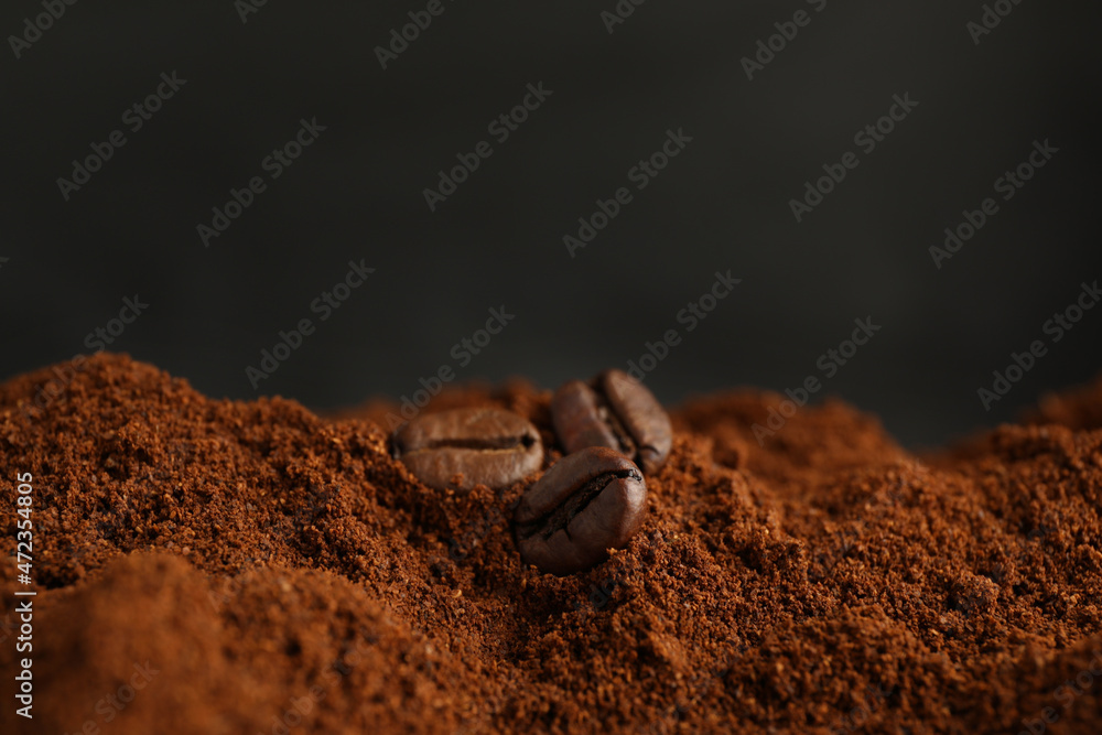 Wall mural coffee grounds and roasted beans on dark background, closeup