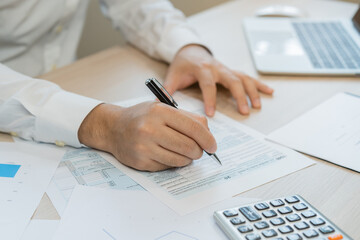 Close up hand of stress asian young employee business man, male calculate tax income and expenses, bills, credit card for payment or payday on table at home office. Financial, finance people concept.