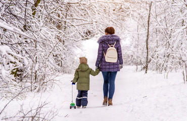 A woman with her son walking in a winter Park
