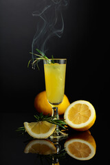 Traditional homemade lemon liqueur limoncello on the black background.