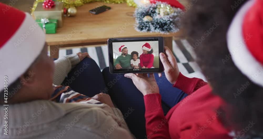 Poster African american mother and daughter using tablet for christmas video call with family on screen