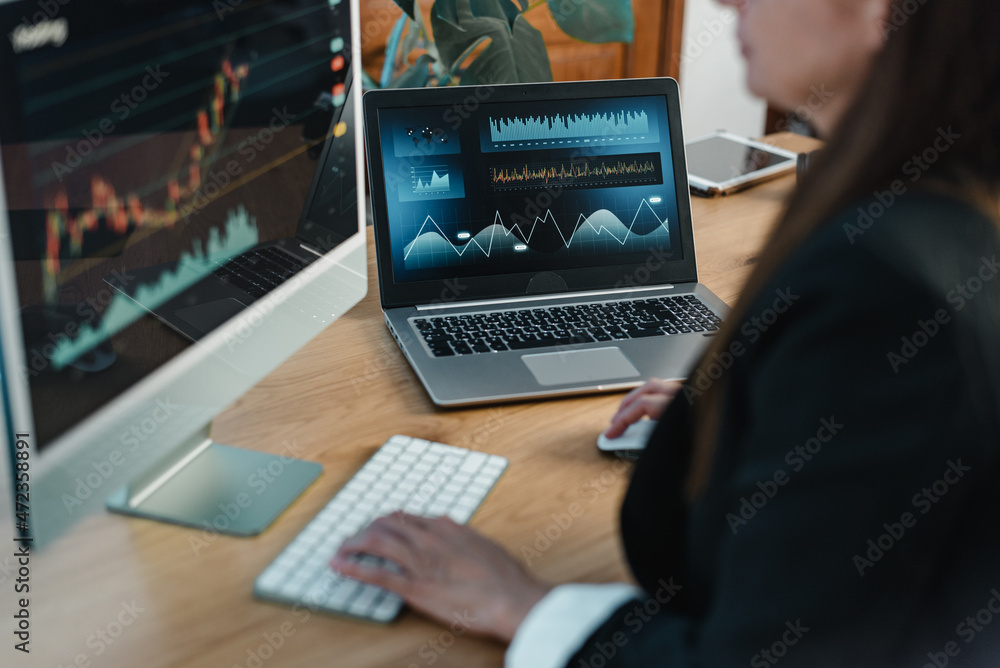 Wall mural crop trader at table with laptop and computer screen