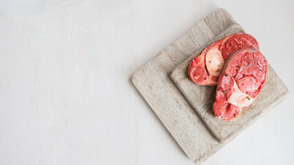 Two fresh raw osso buco meat on wooden try on white background.