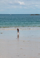   Woman is walking  along the beach in Saint-Malo, Brittany, France