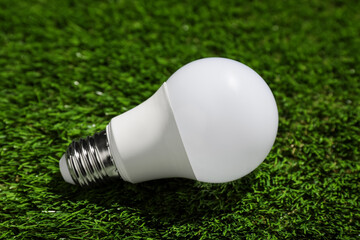 New light bulb on fresh green grass, closeup