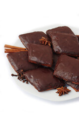 Italian traditional festive cookies called Mostaccioli or Mustaccioli on a plate isolated on white background. Christmas cookies made mith Pisto, a mix of various spices