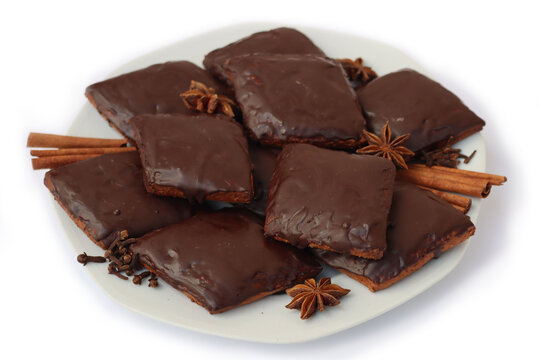 Italian traditional festive cookies called Mostaccioli or Mustaccioli on a plate isolated on white background. Christmas cookies made mith Pisto, a mix of various spices