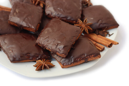 Italian traditional festive cookies called Mostaccioli or Mustaccioli on a plate isolated on white background. Christmas cookies made mith Pisto, a mix of various spices