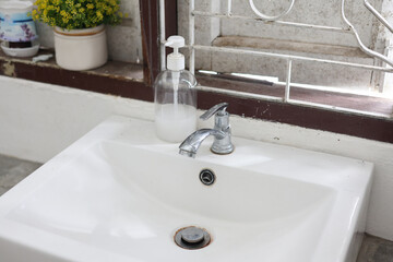 Bathroom simple interior with washbasin and faucet on wooden pedestal
