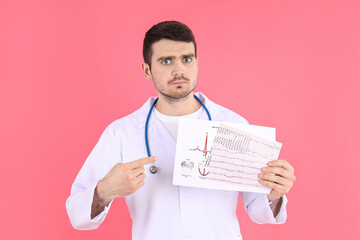 Doctor - intern with cardiogram on pink background