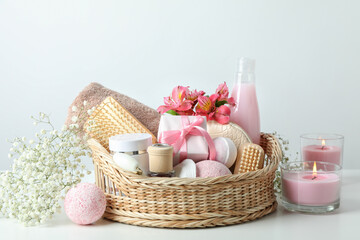 Concept of gift with basket of cosmetics on white table
