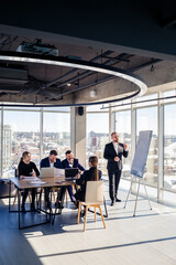 Confident businessman makes a presentation of a new project in the boardroom at a company meeting....