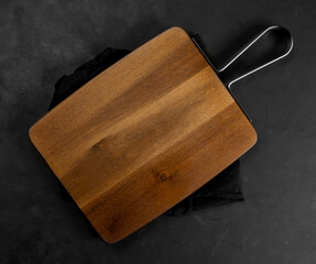 cutting board on a black napkin, dark background.