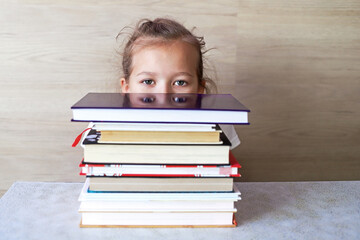 Schoolgirl girl reads books after school to know a lot