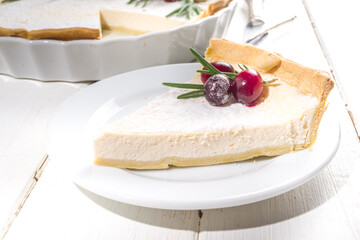 Homemade Christmas pastries, sweet cheesecake pie with powdered sugar, cranberries and rosemary. Christmas  and New Years festive baking background