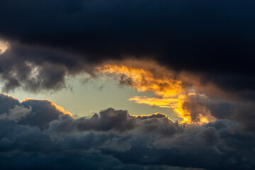 cloudy sky with a small space through which the sunset is visible