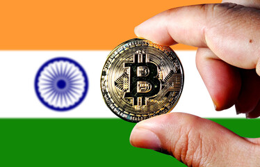 Hold the physical version of Bitcoin (the new virtual currency) and the Indian flag. Indian cryptocurrency and blockchain technology investor concept map 