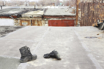 Old shoes thrown away lie on the roof of the garage stink