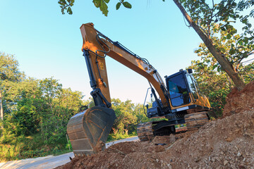  Excavators are digging the soil in the construction site with the tree and  outdoor background - obrazy, fototapety, plakaty
