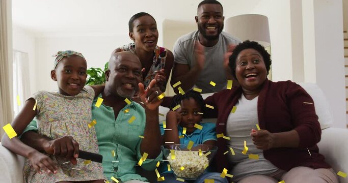 Animation Of Gold Confetti Over Multi Generation Family Watching Sports Celebrating At Home