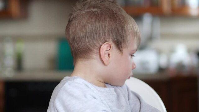 A boy with snot is naughty and turns away