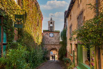 Street with its clock gate in the medieval village of Cordes sur Ciel, in Tarn, Occitanie, France - 472371040