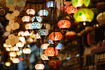 Naklejka premium Mosaic Turkish lanterns in the evening in a souvenir shop.