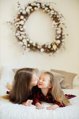 Two little sisters near the Christmas tree.