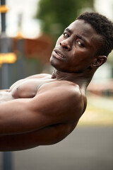 Naklejka na ściany i meble Man doing crunches. Core outdoor workout. Black athlete exercising.