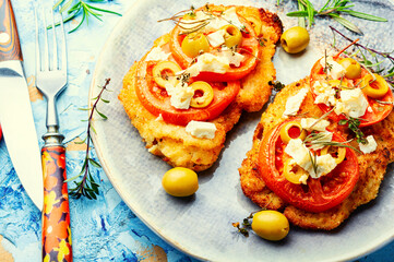 Schnitzel with olives and tomato