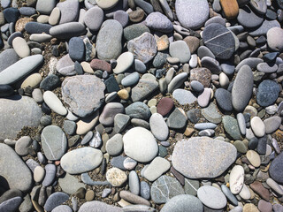 Sea stones background with small pebbles or stone in garden or in the seaside or on a beach. A close up view of rounded smooth polished pebble stones