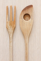 A wooden spoon and wooden fork on a table