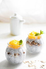 Healthy Chia Pudding with Coconut Milk, mango, chia seeds, granola in a Glass. Concept of healthy eating, healthy lifestyle, dieting, fitness menu. 